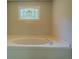A soaking tub beneath a decorative stained glass window adds a touch of elegance to this bathroom at 1201 Justin Ln, Lithonia, GA 30058