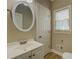 Bathroom featuring a white vanity, oval mirror, and natural light at 1201 Justin Ln, Lithonia, GA 30058