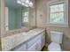Bathroom vanity features white cabinets, a large mirror, and natural light from a nearby window at 1201 Justin Ln, Lithonia, GA 30058