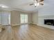 Bright living room featuring wood flooring, a painted brick fireplace, and a large window at 1201 Justin Ln, Lithonia, GA 30058
