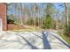 Exterior of a brick home with a side driveway and backyard featuring landscaped areas at 150 Gill Ln, Stockbridge, GA 30281