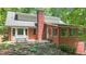 Exterior view of brick home showcasing a stone patio, backyard, and wooded surrounding at 150 Gill Ln, Stockbridge, GA 30281