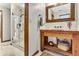 Bathroom featuring a stand-up shower with glass door and a vanity with rustic mirror at 150 Gill Ln, Stockbridge, GA 30281