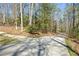 Exterior view of a long driveway splitting into two, surrounded by lush trees at 150 Gill Ln, Stockbridge, GA 30281