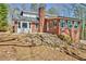 Brick house with an attached sunroom in a wooded setting featuring a rock retaining wall at 150 Gill Ln, Stockbridge, GA 30281