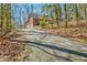 Brick home featuring a long driveway leading to a side-entry garage, surrounded by trees at 150 Gill Ln, Stockbridge, GA 30281