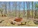 Charming outdoor fire pit with seating area surrounded by natural wooded beauty at 150 Gill Ln, Stockbridge, GA 30281