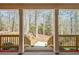 View from the porch of a brick house featuring pillars, railings, and a paved walkway surrounded by trees at 150 Gill Ln, Stockbridge, GA 30281