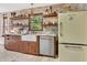Well-lit kitchen with a farmhouse sink, custom cabinets, floating shelves, and a retro-style refrigerator at 150 Gill Ln, Stockbridge, GA 30281