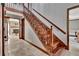 Elegant wooden staircase with decorative railings and stone flooring, leading to an upper level at 150 Gill Ln, Stockbridge, GA 30281