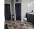 Bathroom featuring tile flooring, a vanity with black cabinets, and a separate door to the toilet at 64 Citadel Dr, Hampton, GA 30228