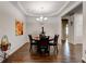 Formal dining room featuring tray ceiling, a chandelier, dark wood floors and seating for four at 64 Citadel Dr, Hampton, GA 30228