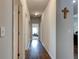 Neutral hallway featuring modern doors, hardwood floors, and decorative cross, leading to other rooms at 64 Citadel Dr, Hampton, GA 30228