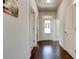 Well-lit hallway with hardwood floors and neutral wall color, leading to multiple rooms at 64 Citadel Dr, Hampton, GA 30228