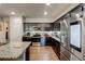 Modern kitchen equipped with stainless steel appliances, dark cabinets and a granite countertop island at 64 Citadel Dr, Hampton, GA 30228