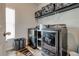 Well-equipped laundry room with modern washer and dryer set and overhead storage shelves at 64 Citadel Dr, Hampton, GA 30228