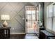 Living room with decorative wall paneling, security door, and a window with blinds, offering style and safety at 64 Citadel Dr, Hampton, GA 30228
