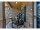 Cozy front porch featuring rocking chairs, decorative pillows, and a brick facade at 64 Citadel Dr, Hampton, GA 30228