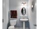 Well-lit powder room with a pedestal sink and decorative mirror, offering convenience and style at 7115 Secret Rose, Douglasville, GA 30134