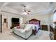 Relaxing main bedroom with a tray ceiling, sitting area, a ceiling fan, and a large TV at 7115 Secret Rose, Douglasville, GA 30134