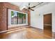 Bright bedroom with hardwood floors, exposed brick accent wall, and ceiling fan at 1261 Caroline Se St # 108, Atlanta, GA 30307