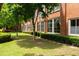 Lush exterior of the building featuring mature trees, green lawn, and manicured hedges at 1261 Caroline Se St # 108, Atlanta, GA 30307