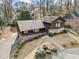 Aerial view of home featuring driveway, brick and stone exterior, well maintained lawn, and manicured landscaping at 1905 Castleway Ne Ln, Atlanta, GA 30345
