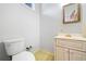 Cozy bathroom with white toilet, white sink with ornate mirror and gold fixtures on speckled yellow floor at 1905 Castleway Ne Ln, Atlanta, GA 30345