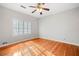 Bright bedroom featuring beautiful hardwood floors, a ceiling fan, and a large window with plantation shutters at 1905 Castleway Ne Ln, Atlanta, GA 30345