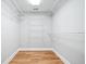 Walk-in closet featuring hardwood floors and white shelving with ample storage space at 1905 Castleway Ne Ln, Atlanta, GA 30345