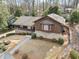 Aerial view of this home showcasing the stone and wood exterior with mature landscaping at 1905 Castleway Ne Ln, Atlanta, GA 30345