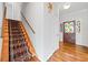 Inviting foyer with hardwood floors, a colorful stained-glass front door, and carpeted stairs at 1905 Castleway Ne Ln, Atlanta, GA 30345