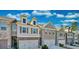Attractive townhome exterior with a well-maintained lawn and attached garages underneath a partly cloudy, blue sky at 2711 Kemp Ct, Conyers, GA 30094