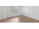 Bright bedroom featuring wood flooring, a large window, and a doorway at 3468 Washington Way, Doraville, GA 30340