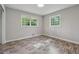 Bright bedroom with neutral walls, wood-look floors, and two windows providing natural light at 4616 Greensprings Rd, Atlanta, GA 30337