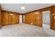 Spacious living room featuring wood paneled walls, plush carpet, and several doorways at 4616 Greensprings Rd, Atlanta, GA 30337
