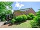Brick home with a screened-in porch and lush landscaping in the backyard at 1460 Badingham Dr, Cumming, GA 30041