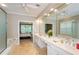 Bright bathroom with double vanity sinks and a view to the main bedroom, offering convenience and style at 1460 Badingham Dr, Cumming, GA 30041