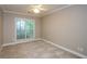 Bright bedroom featuring a ceiling fan, a large window, neutral color scheme, and plush carpet at 1460 Badingham Dr, Cumming, GA 30041