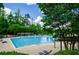 Inviting community pool, surrounded by mature trees, offers a refreshing escape with ample space for recreation and relaxation at 1460 Badingham Dr, Cumming, GA 30041