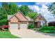 Charming brick home featuring a well-manicured lawn, two-car garage, and beautiful landscaping at 1460 Badingham Dr, Cumming, GA 30041