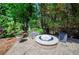 Stone fire pit with seating area in a landscaped backyard, perfect for outdoor entertaining at 1460 Badingham Dr, Cumming, GA 30041