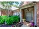 Inviting front entryway with a gray door, brick facade, and beautiful landscaping at 1460 Badingham Dr, Cumming, GA 30041