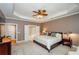 Serene main bedroom offering a trey ceiling, soft carpet, and easy access to an attached ensuite bathroom at 1460 Badingham Dr, Cumming, GA 30041