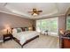 Comfortable primary bedroom with tray ceiling, large windows, and plush carpeting for a relaxing retreat at 1460 Badingham Dr, Cumming, GA 30041