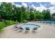Community pool with a splash pool surrounded by trees and lounge chairs at 1460 Badingham Dr, Cumming, GA 30041