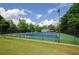 Well-maintained outdoor tennis courts with green fencing and lush surroundings at 1460 Badingham Dr, Cumming, GA 30041
