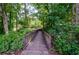 Wooden walking bridge surrounded by lush greenery and mature trees at 1460 Badingham Dr, Cumming, GA 30041