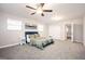A spacious bedroom with a ceiling fan, plush gray carpet, and a bed with a patterned green quilt and bedside tables at 1887 King Charles Sw Rd, Atlanta, GA 30331