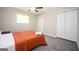 This bedroom features plush gray carpets, a ceiling fan, and a bed with white towels on top of the orange quilt at 1887 King Charles Sw Rd, Atlanta, GA 30331